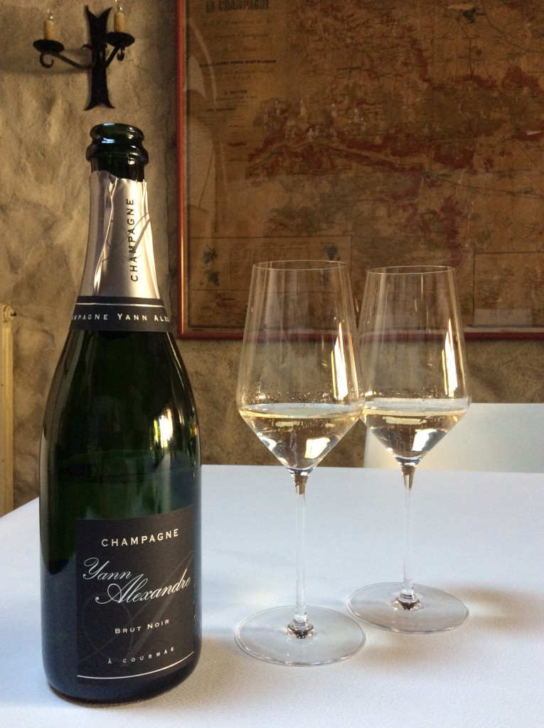 A bottle of Yann Alexandre champagne sits next to two glasses of champagne